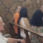 No vídeo gravado por uma pessoa que estava no local mostra o homem abraçado com a mulher, enquanto prestam atenção na missa.(Foto: reprodução vídeo)