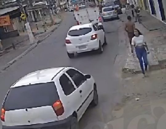 Uma câmera de segurança flagrou a vítima ainda tentando desvencilhar-se do suspeito, mas acabou sendo sequestrada, mesmo com as pernas para fora do veículo. (Foto: Reprodução videomonitoramento)