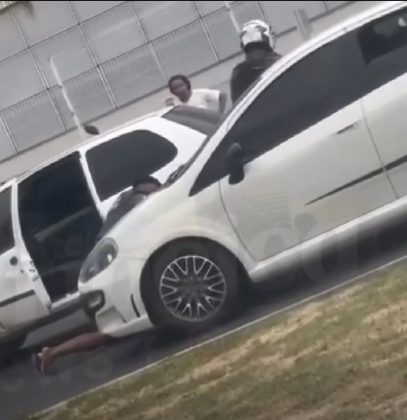 Em alguns segundos, um homem vestido de azul sai do carro e puxa a vítima. Ela tenta fugir, mas acaba arrastada. (Foto: Reprodução videomonitoramento)