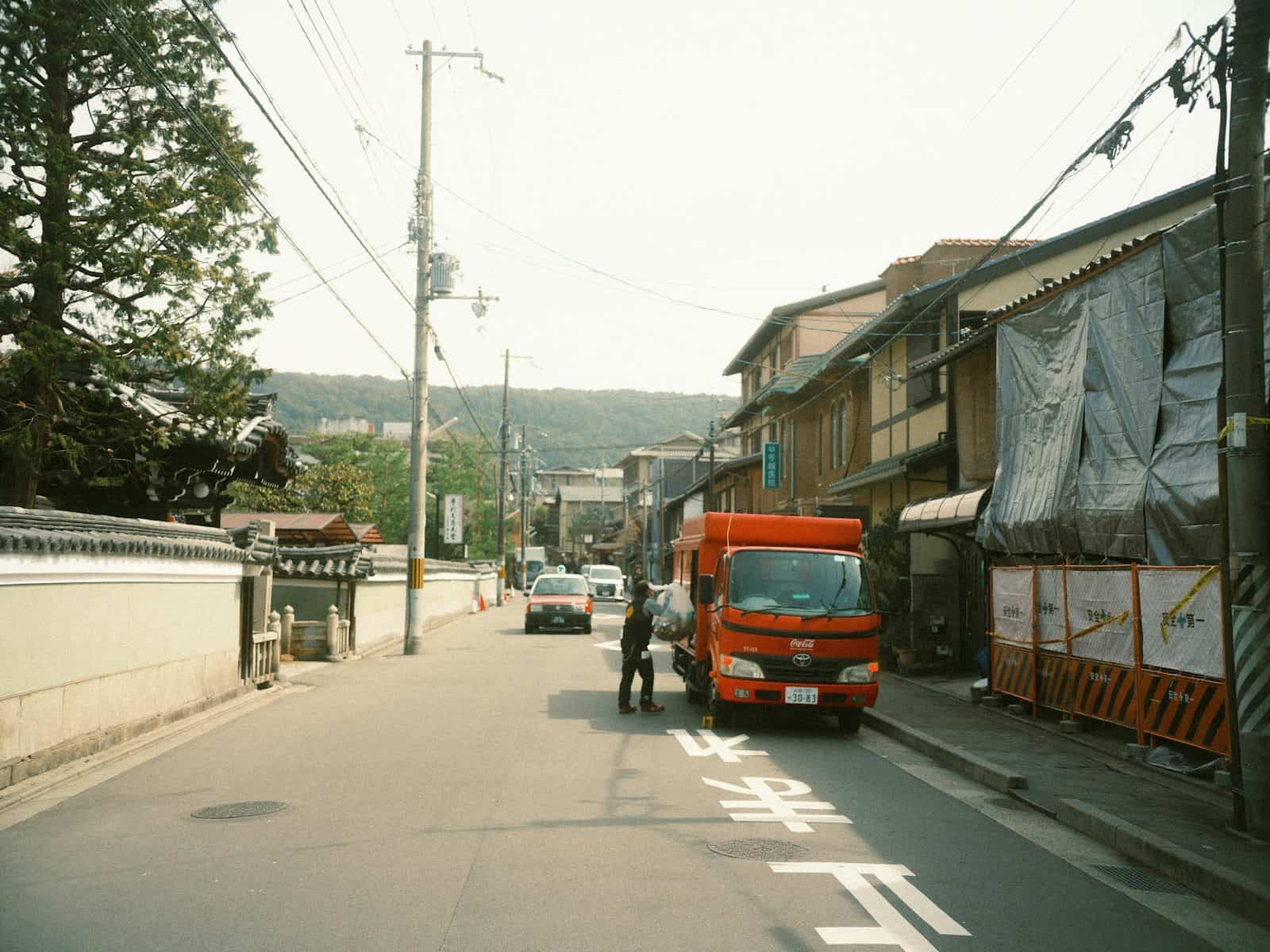 A street with vehicles, buildings and people