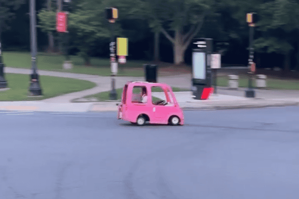 Cena curiosa mostra microcarro rosa circulando normalmente em avenida