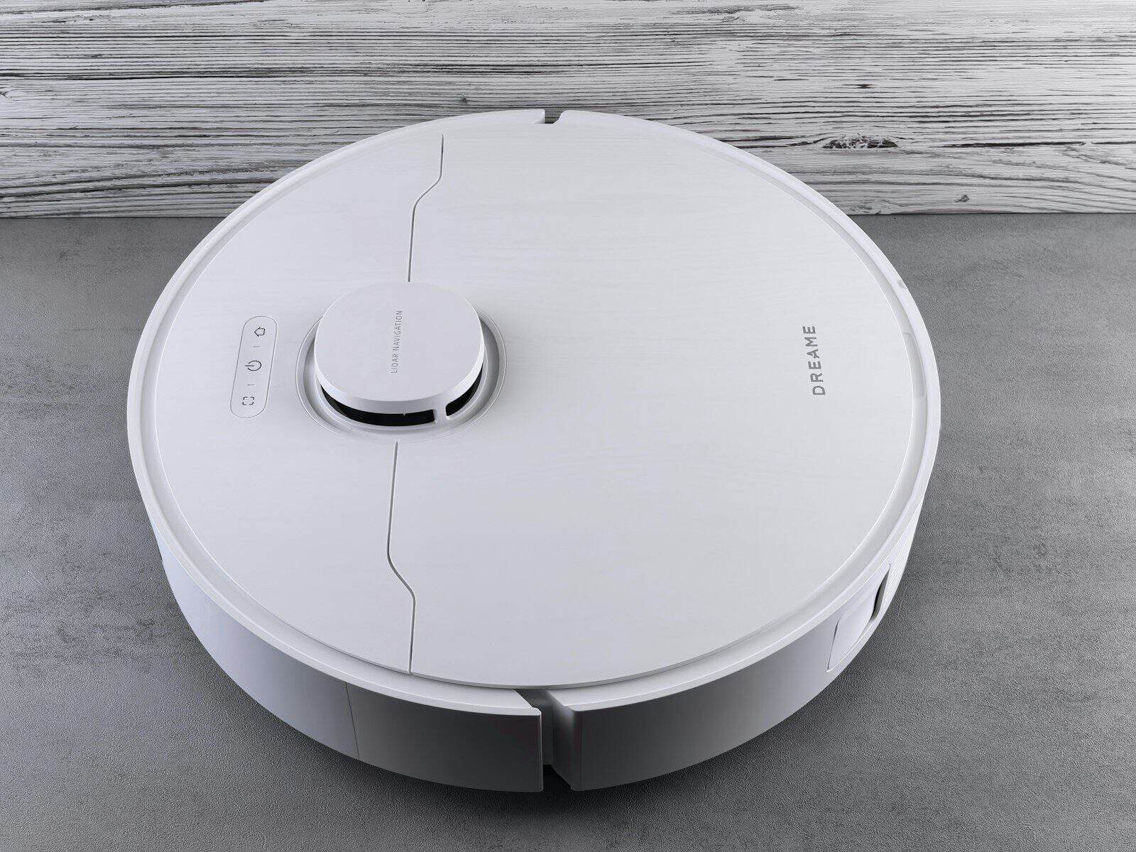A white robot vacuum cleaner on a grey floor