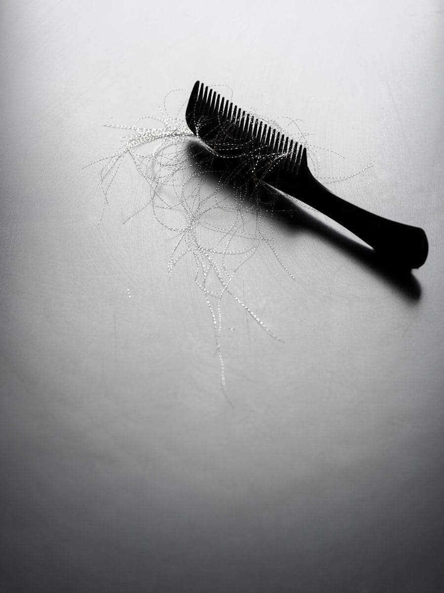 A black comb with loose strands of hair