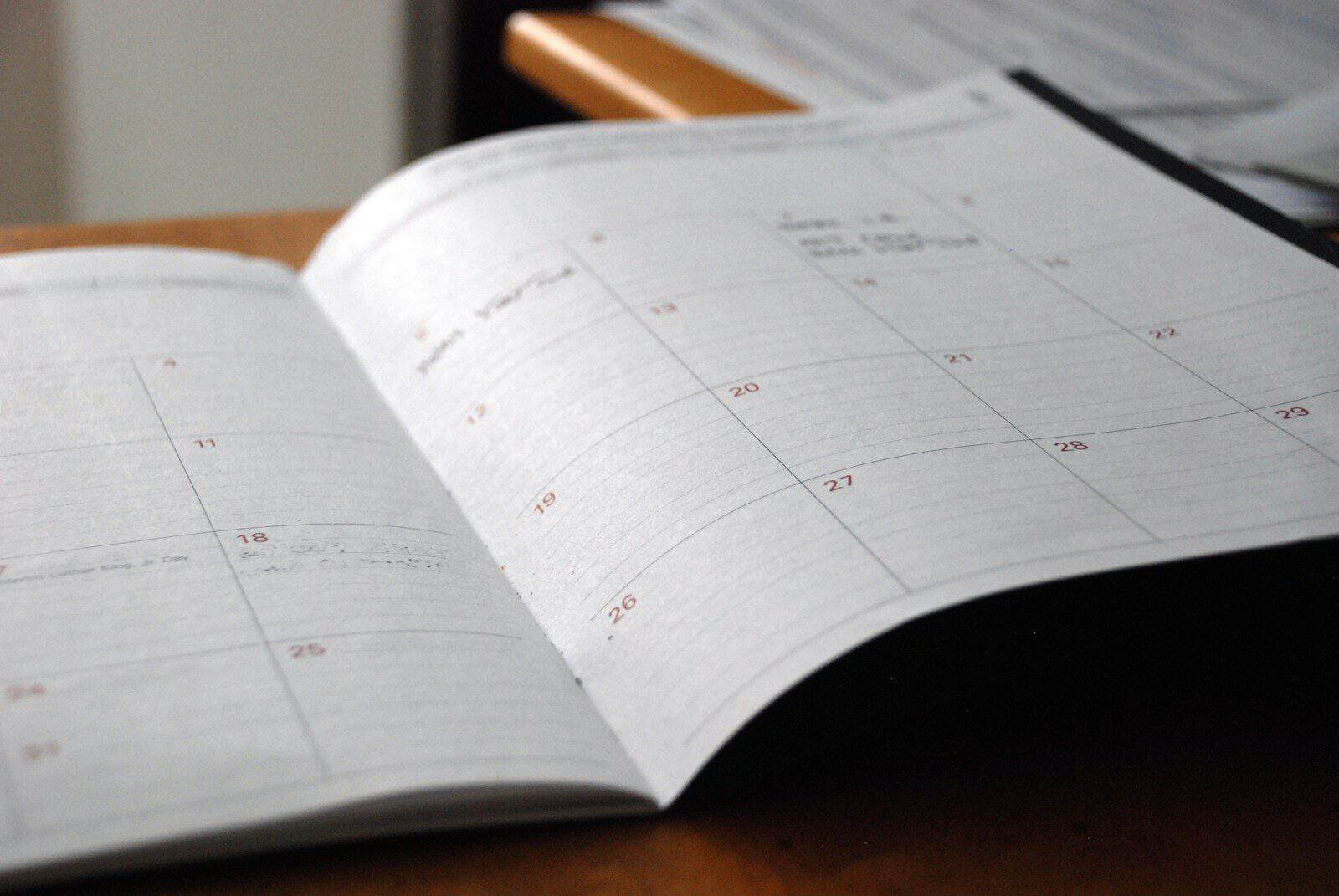 open monthly planner on wooden desk