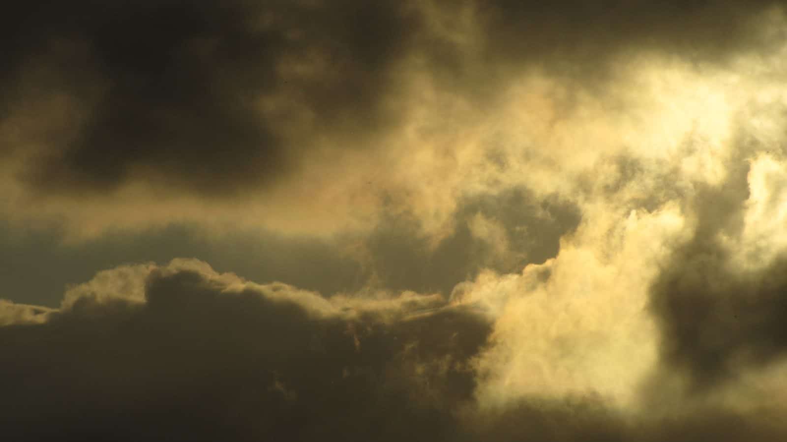Dramatic golden sunlight breaking through dark clouds