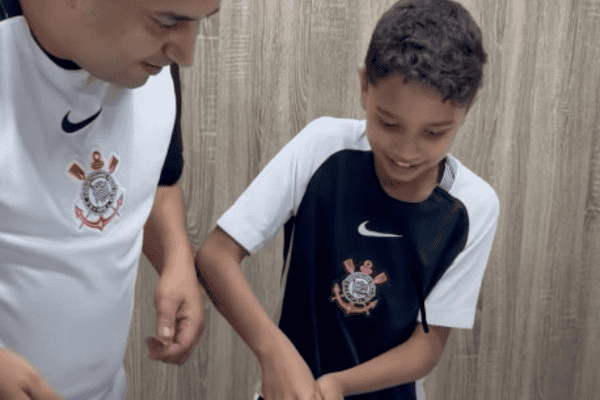 Na hora de cortar o bolo, este garoto foi surpreendido com um presente do pai e não conteve a emoção