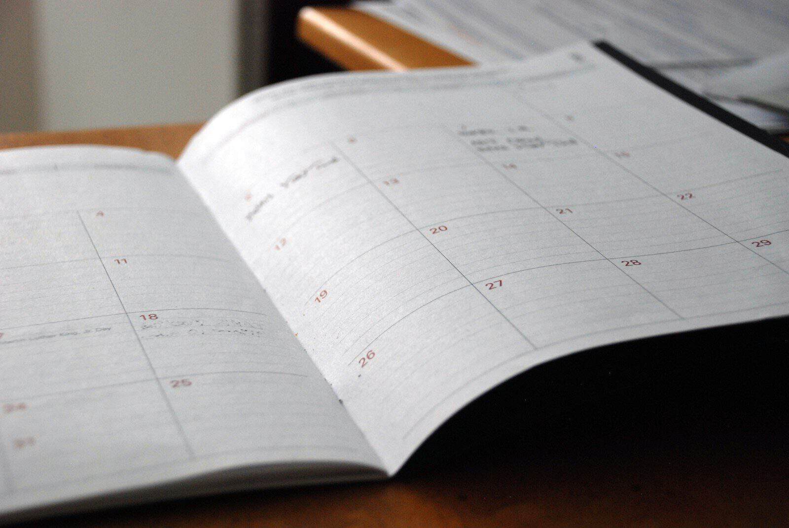 open monthly planner on wooden desk