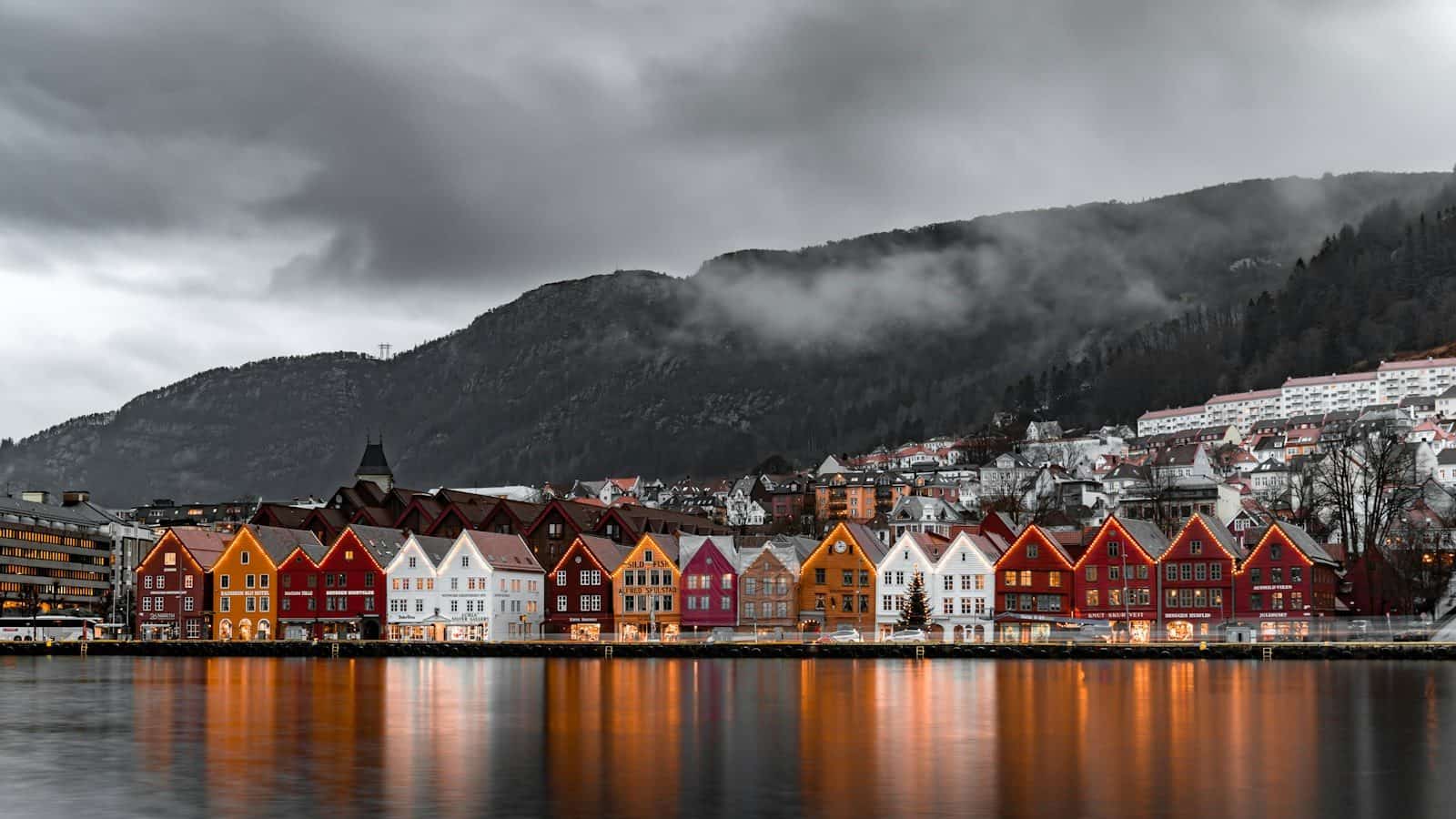 Colorful wooden houses along the Bryggen wharf in Bergen under a cloudy sky