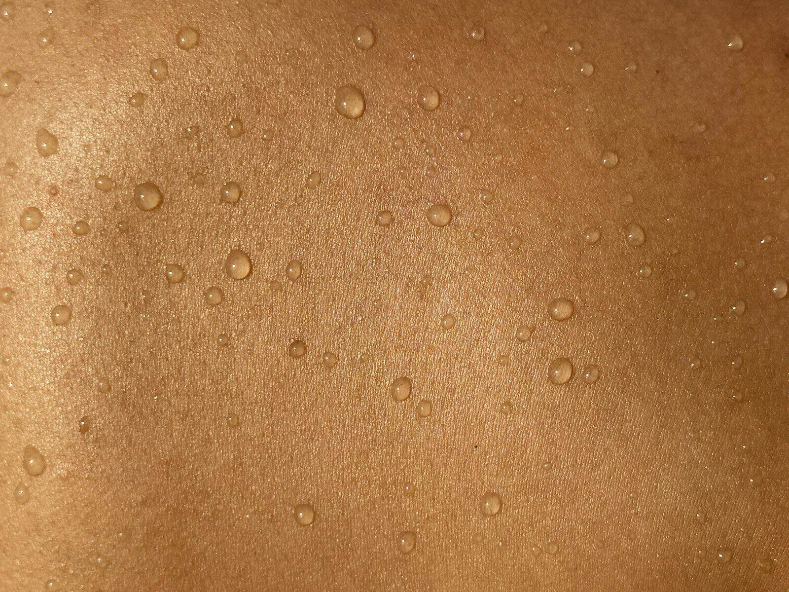 A man's back with water drops on it