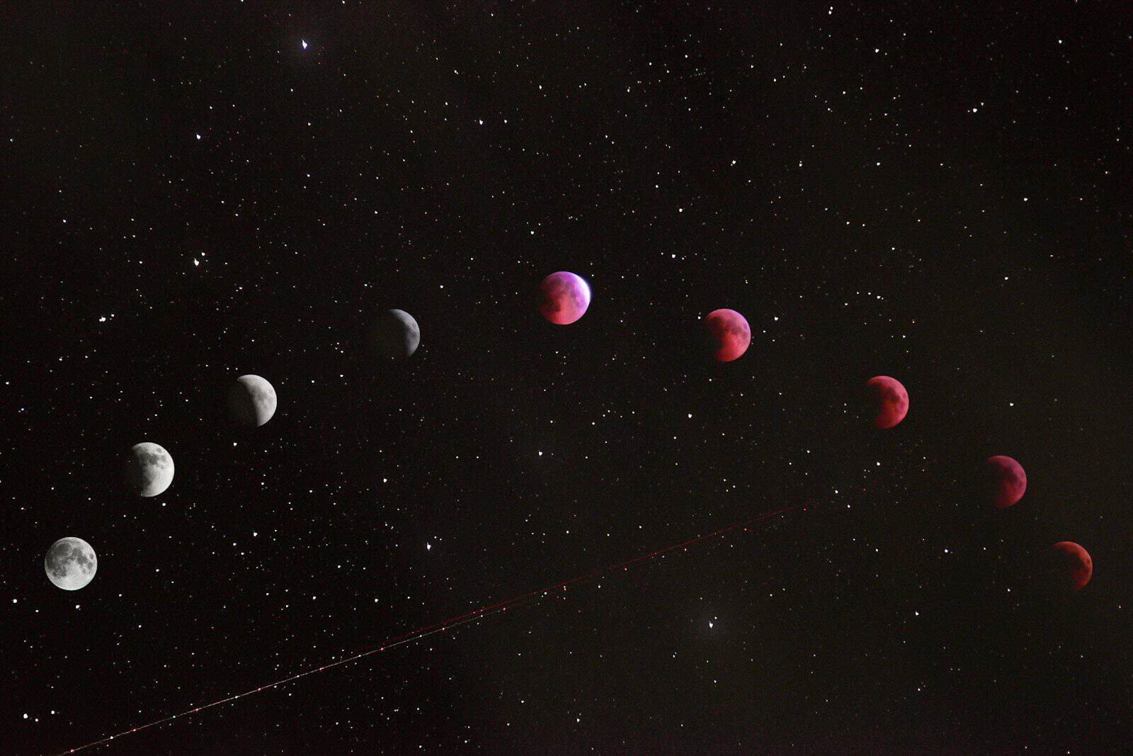 A sequence of lunar eclipse phases across a dark starry night sky