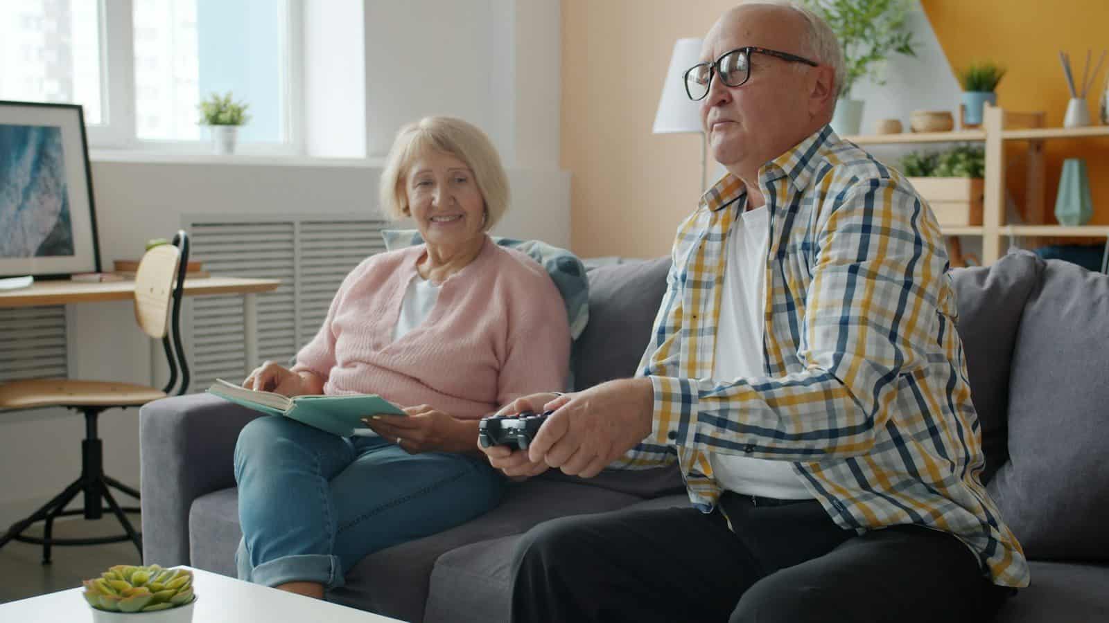 Elderly couple playing video games on the couch
