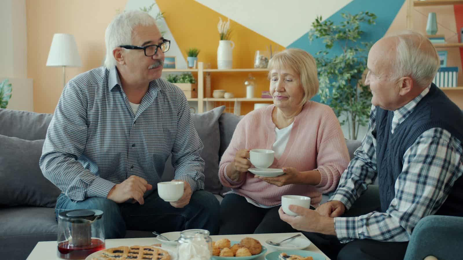 Three seniors enjoying coffee and conversation at home