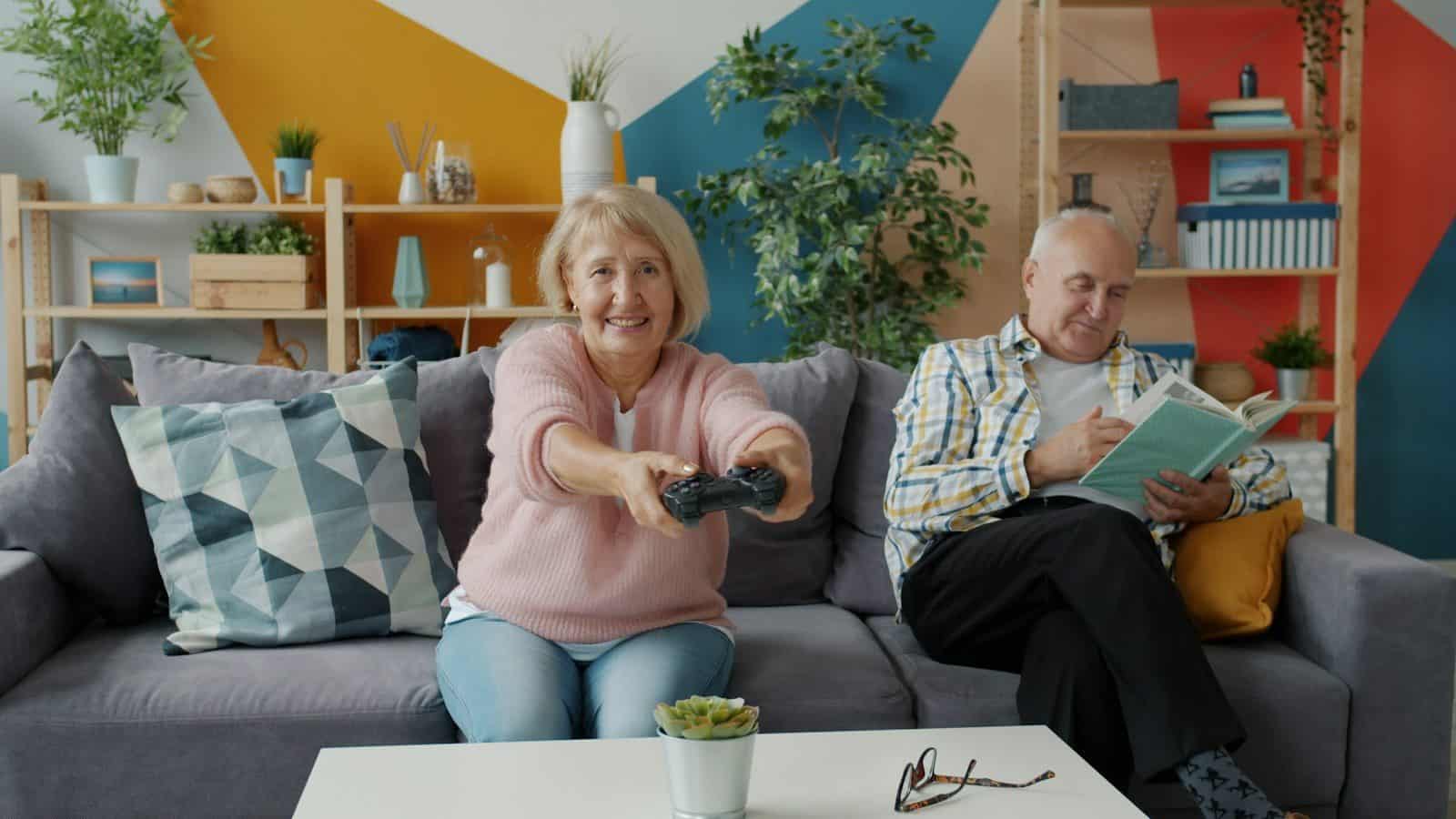 Elderly couple playing video games and reading