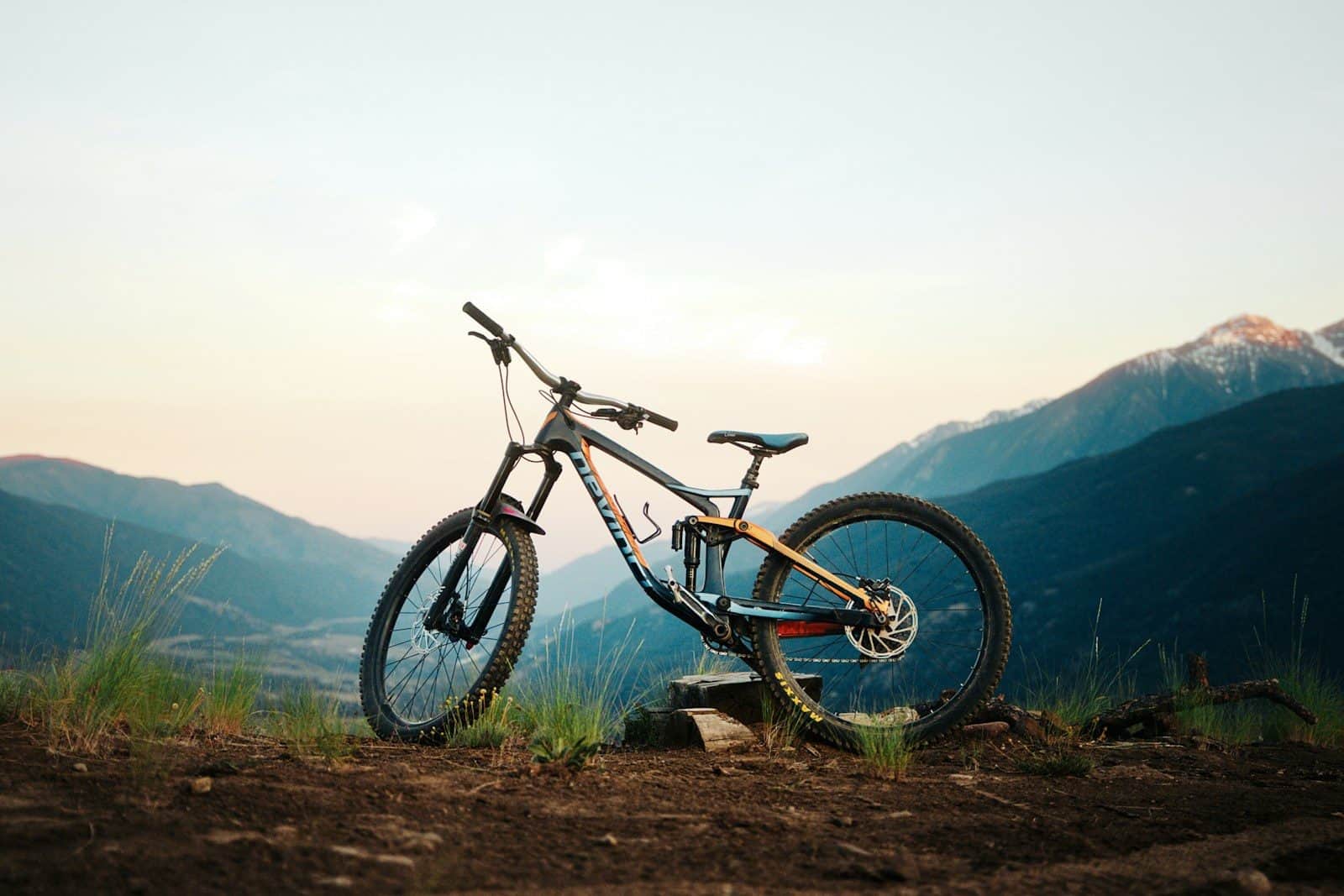 Mountain bike parked on a trail with mountains at sunset
