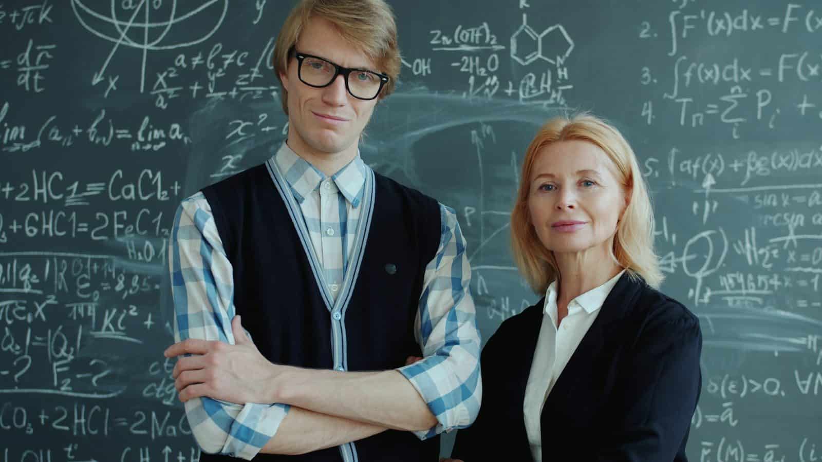 A young man and older woman in front of chalkboard