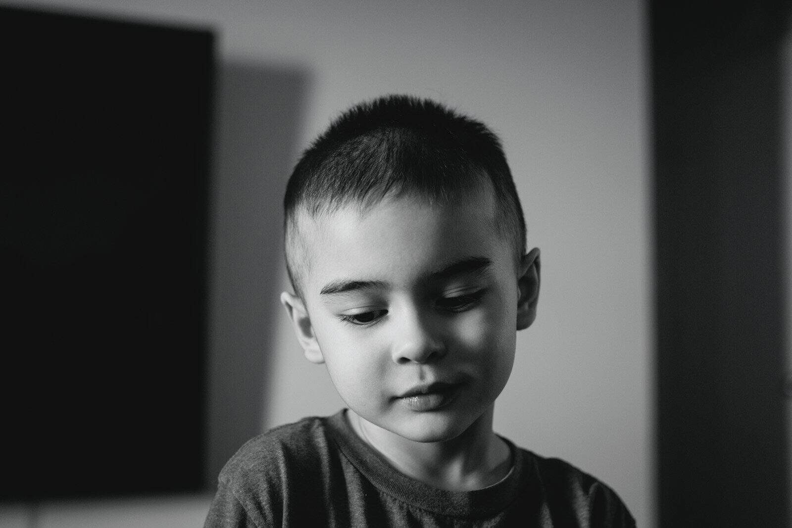 A young boy looking down with eyes closed
